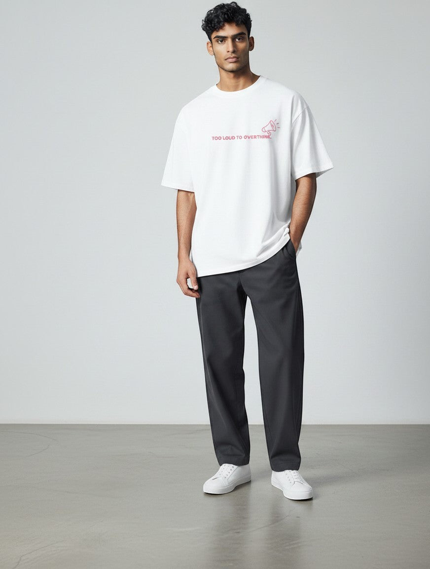 Male model wearing a white mi-DONE oversized cotton t-shirt with red graphic print and dark grey trousers