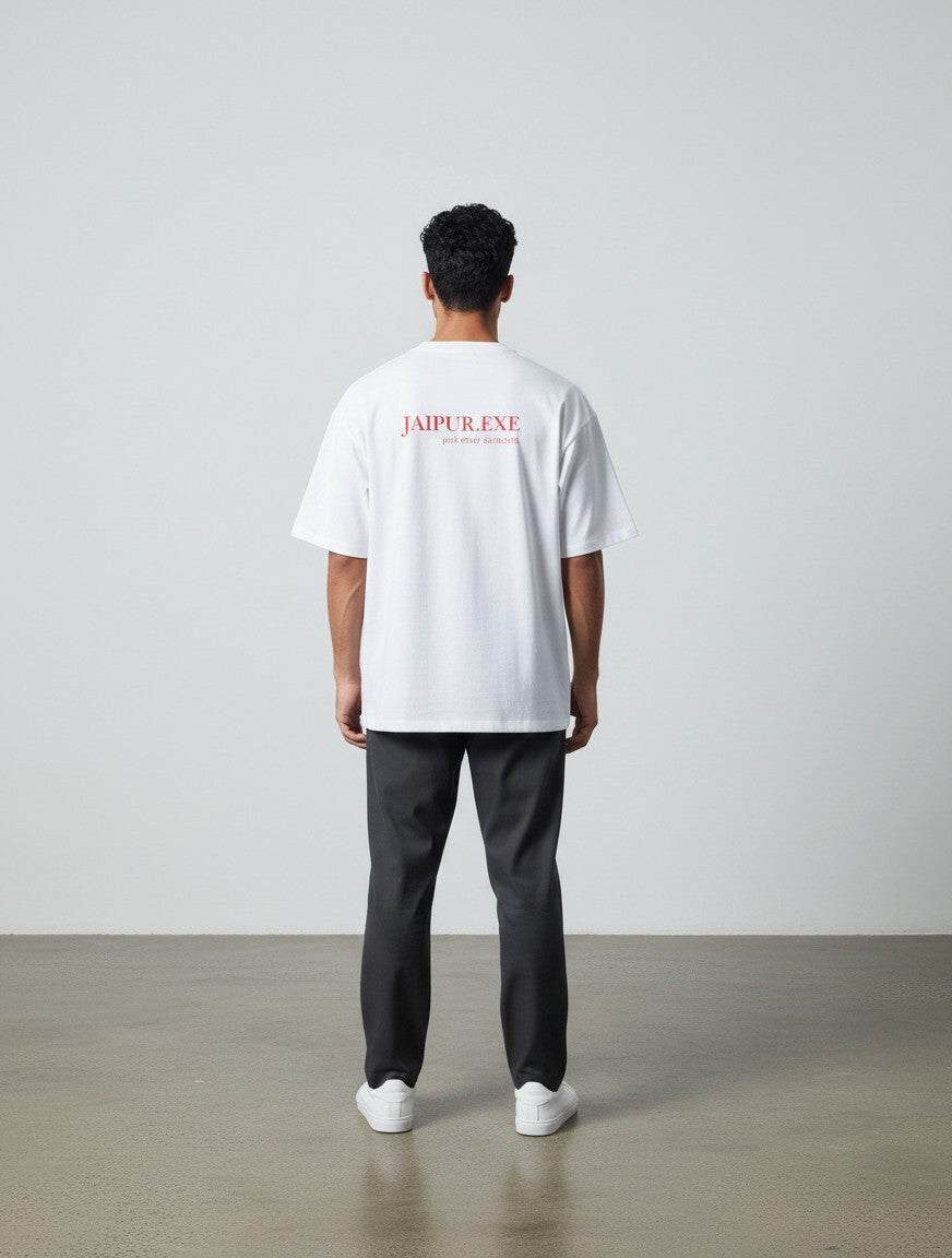 mi-DONE white oversized cotton t-shirt with Jaipur.exe red graphic print on back, worn by a man with dark trousers.