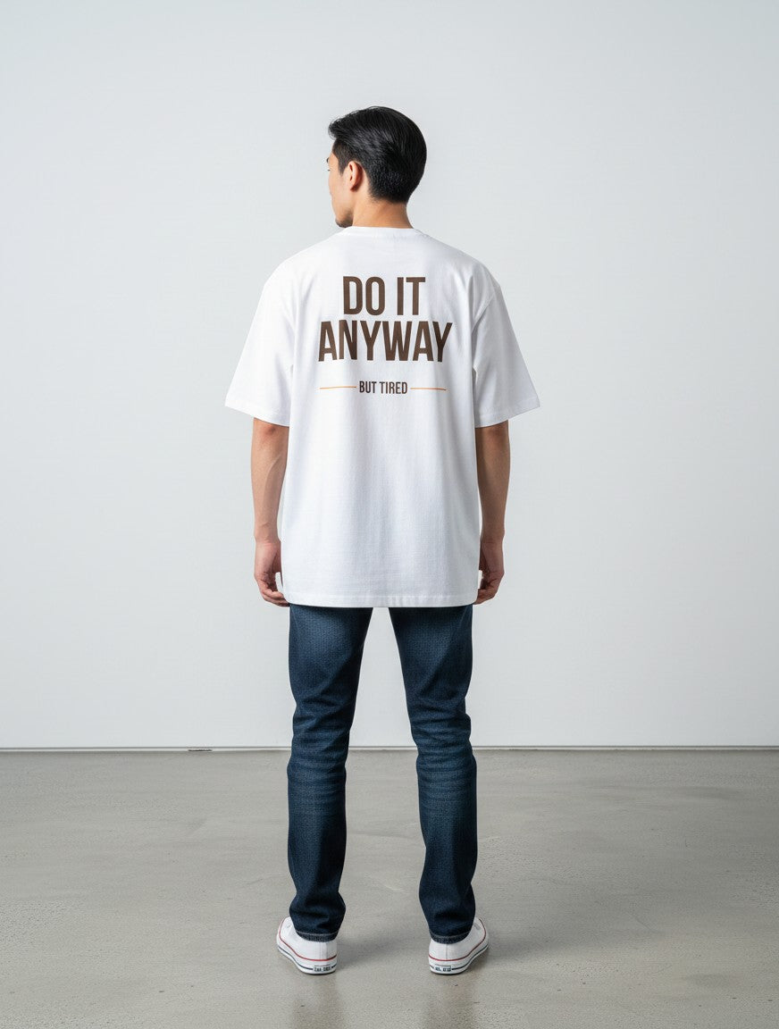mi-DONE white oversized cotton t-shirt with Do It Anyway But Tired back print worn by a man with dark jeans