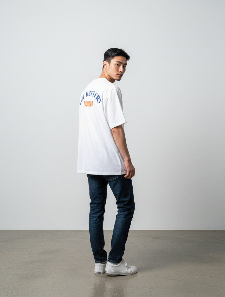mi-DONE white oversized cotton t-shirt with Low Battery graphic print on back worn by a man with blue jeans