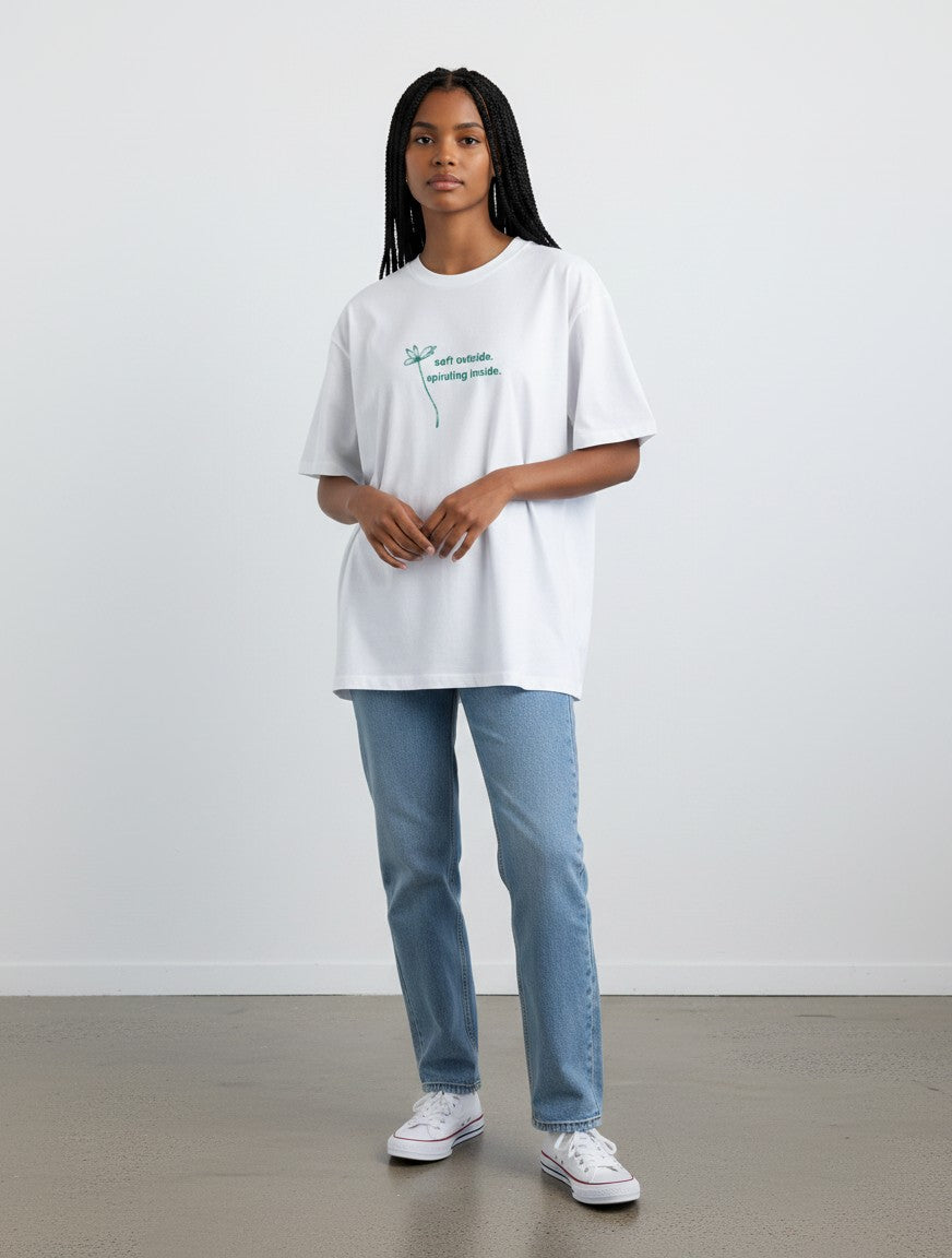 A model wearing a white mi-DONE oversized cotton t-shirt with a green graphic print and blue jeans.