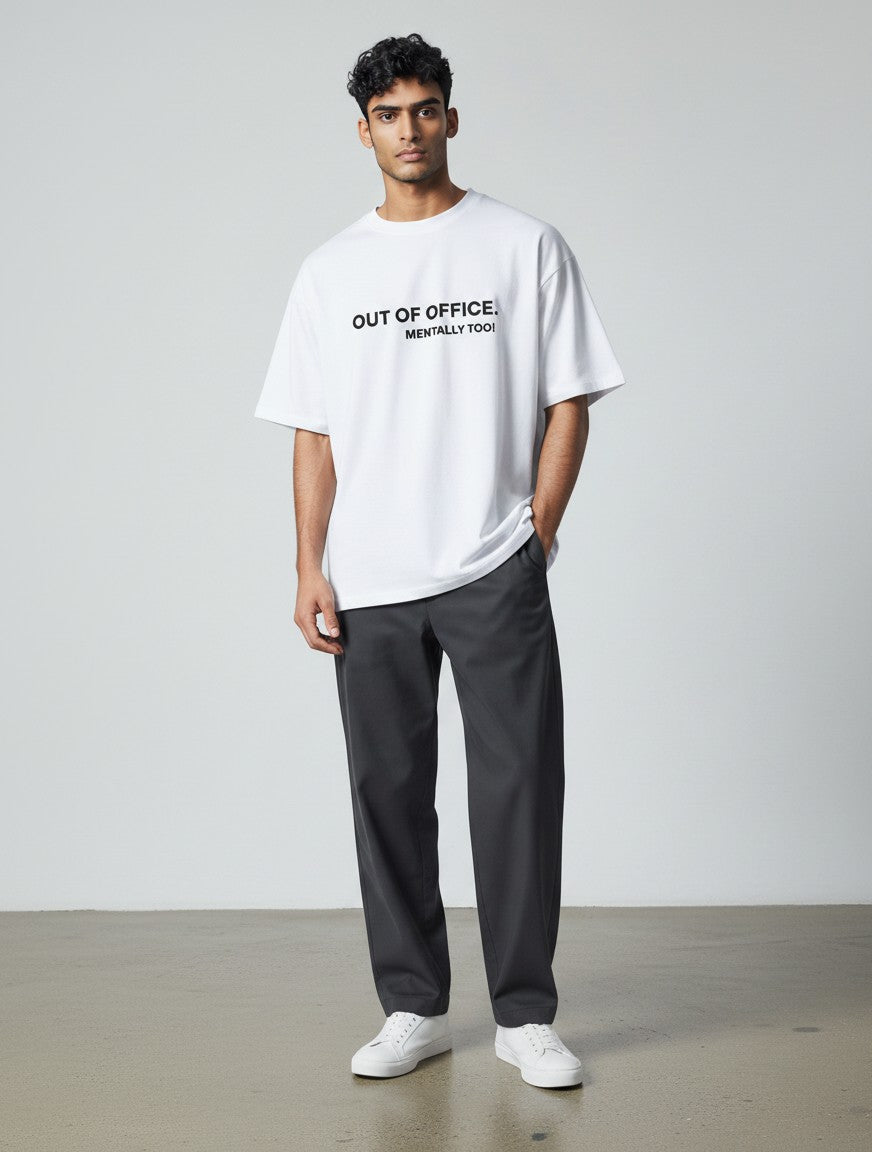 mi-DONE white oversized cotton t-shirt with Out of Office graphic print worn by a male model with dark trousers