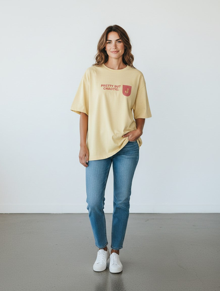 Woman wearing a yellow mi-DONE oversized cotton t-shirt with Pretty But Chaotic graphic print and drop shoulders